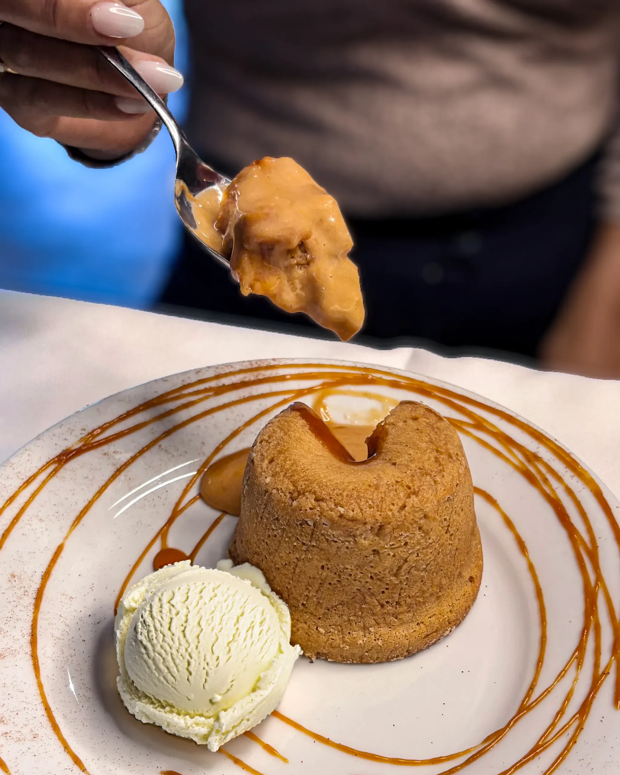 Postre volcán de dulce de leche servido en buffet, combinación de bizcocho caliente y helado.