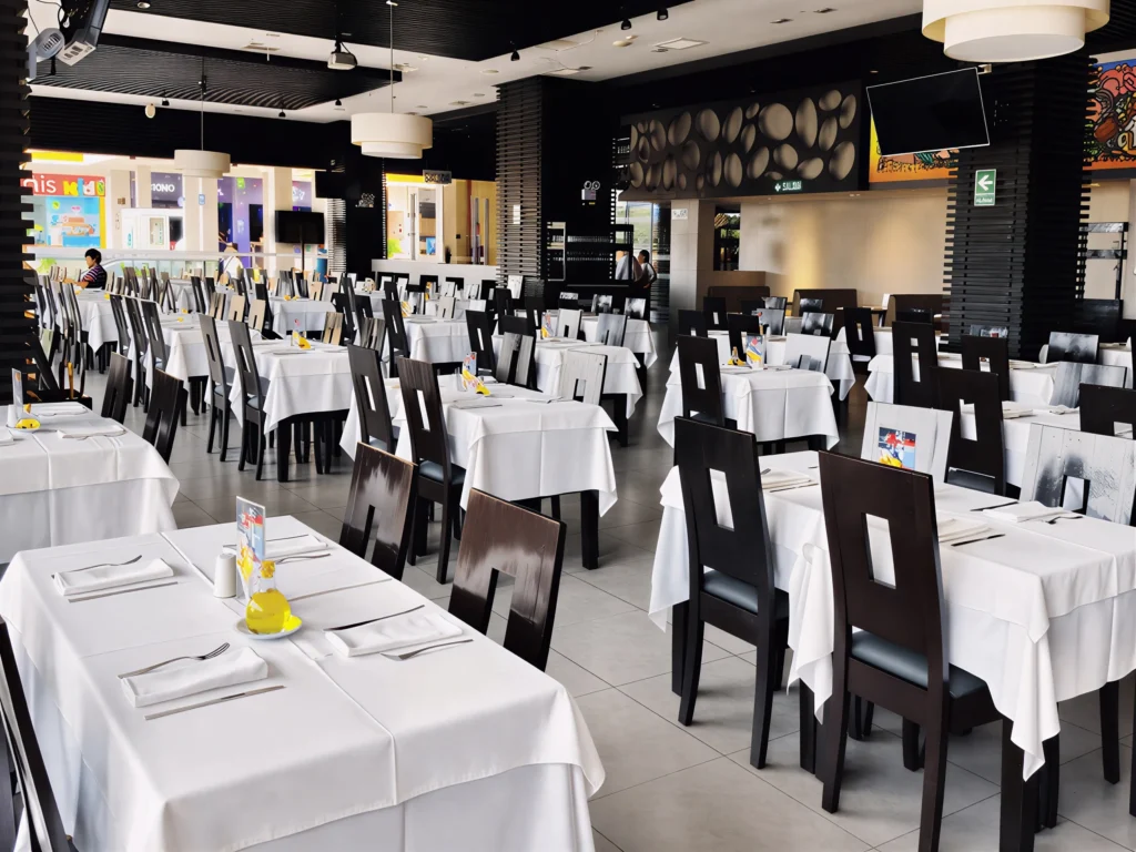 Interior del salón principal de La Bistecca San Miguel con mesas elegantemente servidas para el buffet.