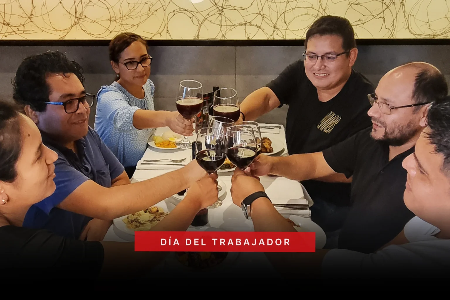 Grupo de amigos brindando con copas en el buffet de La Bistecca para celebrar el Día del Trabajador en Lima.
